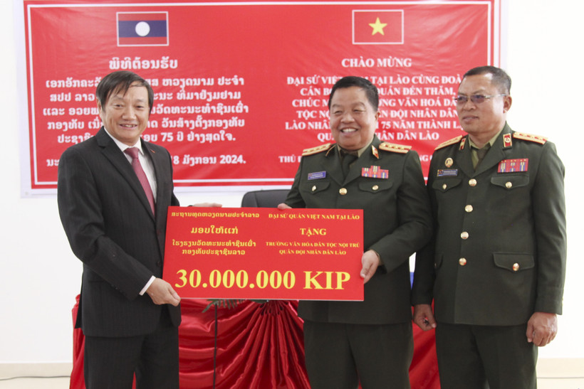 Đại sứ Nguyễn Bá Hùng thay mặt Đại sứ quán Việt Nam tại Lào tặng quà cho Ban Giám hiệu Trường Văn hóa Dân tộc Nội trú Quân đội Nhân dân Lào. (Ảnh: Đỗ Bá Thành/TTXVN)