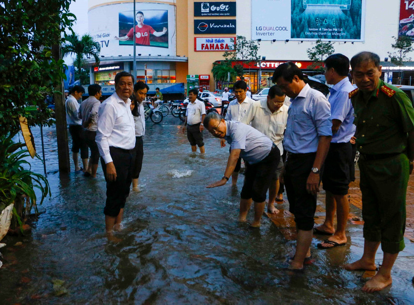 Phó Bí thư Thường trực Thành ủy, Chủ tịch Hội đồng Nhân dân thành phố Cần Thơ Phạm Văn Hiểu cùng lãnh đạo quận Ninh Kiều kiểm tra triều cường gây ngập trên đường Mậu Thân. (Ảnh: Thanh Liêm/TTXVN)