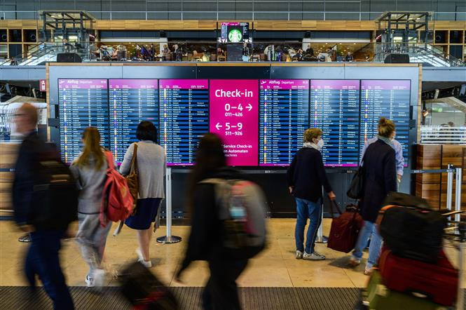Hành khách kiểm tra thông tin các chuyến bay tại Sân bay Quốc tế Berlin Brandenburg (Đức). (Ảnh: AFP/TTXVN)