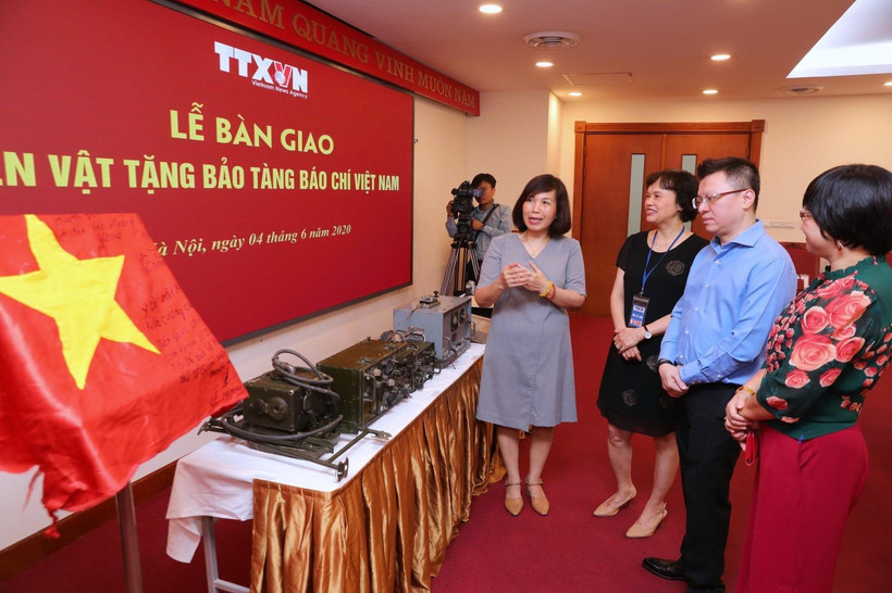 Ông Lê Quốc Minh, Phó Tổng Giám đốc, Chủ tịch Liên Chi hội Nhà báo TTXVN cùng các đại biểu tham quan các hiện vật quý về Báo chí Việt Nam. (Ảnh: Thành Đạt/TTXVN)