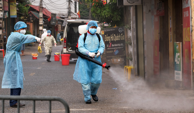 Lực lượng chức năng phun khử khuẩn tại thôn Hạ Lôi (Mê Linh). (Ảnh: Phạm Hùng/TTXVN phát)