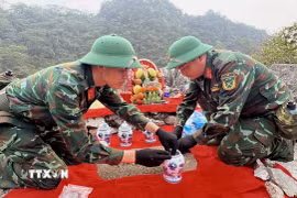 Hài cốt liệt sỹ được cất bốc, đặt vào bình sứ để khâm niệm. (Ảnh: Đức Thọ/TTXVN)