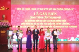 Lãnh đạo phường Thượng Cát (Hà Nội) trao quyết định gắn biển cho đại diện các gia đình và tổ dân phố Hoàng Xá. (Ảnh: Nguyễn Cúc/TTXVN)