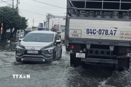 Ngập nặng trên Quốc lộ 1A đoạn đi qua tỉnh Cà Mau khiến giao thông hết sức khó khăn. (Ảnh: Trung Hiếu/TTXVN)