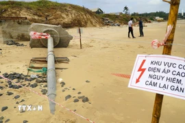 Ngành chức năng chăng dây, cắm biển cảnh báo nguy hiểm tại vị trí cáp ngầm 22kV lộ thiên còn mang điện. (Ảnh: Lê Phước Ngọc/TTXVN)