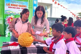 Giáo viên và học sinh trường Tiểu học Kim Đồng, xã Tu Mơ Rông (Quảng Ngãi) bỏ tiền heo đất gây quỹ duy trì bữa ăn trưa miễn phí và hỗ trợ cho những học sinh nghèo, mồ côi không thuộc diện bán trú. (Ảnh: TTXVN phát) 