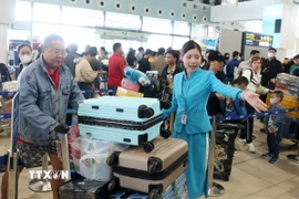 Mặc dù đông nhưng người dân, hành khách vẫn nhận được sự phục vụ, hướng dẫn nhiệt tình từ nhân viên mặt đất. (Ảnh: Quốc Khánh/TTXVN)