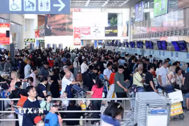 Hành khách xếp hàng đợi làm thủ tục tại sân bay Nội Bài. (Ảnh: Quốc Khánh/TTXVN)