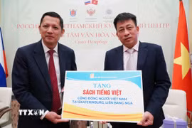 Tổng biên tập Nhà xuất bản Giáo dục Phạm Vĩnh Thái (phải) trao tượng trưng sách cho cộng đồng Việt Nam tại Liên bang Nga. (Ảnh: Tâm Hằng/TTXVN)