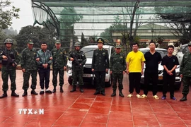 Các đối tượng tổ chức đưa đón người vượt biên trái phép bị bộ đội biên phòng bắt giữ. (Ảnh: TTXVN phát)