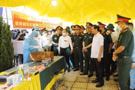 Đoàn công tác kiểm tra quy trình lấy mẫu hài cốt liệt sĩ phục vụ giám định ADN tại Nghĩa trang liệt sỹ Cầu Lồ, xã Bắc Lũng. (Ảnh: TTXVN phát)
