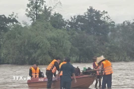 Lực lượng quân đội kịp thời cứu hộ người dân bị cô lập do mưa lớn. (Ảnh: TTXVN phát)