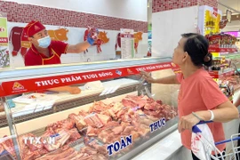 Người dân mua thịt lợn tài quầy Vissan trong siêu thị Co.opmart Lý Thường Kiệt, TP. Hồ Chí Minh. (Ảnh: Hương Giang/TTXVN)