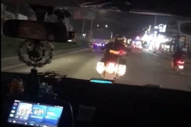 Cán bộ Trạm Cảnh sát giao thông Hưng Phú dẫn đường cho xe ô tô chở bệnh nhân nghi đột quỵ đến cấp cứu tại bệnh viện. (Ảnh: TTXVN phát)