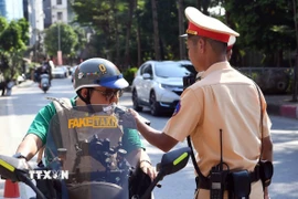 Cán bộ, chiến sĩ đội CSGT số 2, Công an thành phố Hà Nội kiểm tra nồng độ cồn với các chủ phương tiện tham gia giao thông tại tuyến phố Đội Cấn-Liễu Giai. (Ảnh: Phạm Kiên/TTXVN)