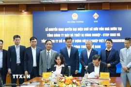 Thứ trưởng Bộ Công Thương Phan Thị Thắng và Chủ tịch Hội đồng thành viên SCIC Nguyễn Chí Thành ký kết biên bản. (Ảnh: Trần Việt/TTXVN)