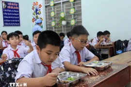 Học sinh vui vẻ với bữa ăn bán trú do Nhà trường tổ chức nấu. (Ảnh: Phan Sáu/TTXVN)