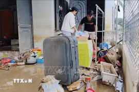 Người dân xã Ninh Phước (Khánh Hòa) dọn dẹp nhà cửa sau mưa lũ. (Ảnh: Nguyễn Thành/TTXVN)