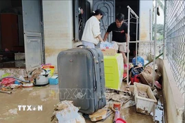 Người dân xã Ninh Phước (Khánh Hòa) dọn dẹp nhà cửa sau mưa lũ. (Ảnh: Nguyễn Thành/TTXVN)
