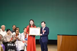 Bà Lê Thương, Chủ tịch Hiệp hội Người Việt Nam vùng Kansai, nhận “Giải thưởng cộng đồng cho công dân toàn cầu” do IHA trao tặng. (Ảnh: Nguyễn Tuyến/TTXVN)