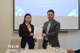 Chị Nguyễn Thị Bích Diệp của ASVI và Francesco Maringiò của Fondazione Italy-Vietnam ký thỏa thuận hợp tác. (Ảnh: Trường Dụy/TTXVN)