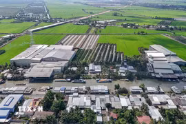 Các nhà máy xay xát lúa gạo ven kênh Thốt Nốt (ấp Thạnh Hưng, xã Cờ Đỏ) phát tán bụi ra môi trường gây ảnh hưởng đến khu dân cư đối diện. (Ảnh: Thanh Liêm/TTXVN)