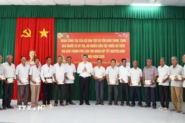 Thứ trưởng Bộ Dân tộc và Tôn giáo Y Vinh Tơr trao quà Tết cho người có uy tín tại xã Mỹ Hương. (Ảnh: TTXVN phát)