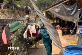 Cán bộ, chiến sỹ Bộ Chỉ huy quân sự tỉnh Lào Cai giúp bà con xã Bắc Hà lợp lại mái nhà, nhanh chóng ổn định cuộc sống. (Ảnh: TTXVN phát)