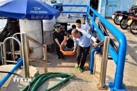 Khẩn trương chuyển thủy thủ Choi MyoungSub người Hàn Quốc lên bờ đi cấp cứu. (Ảnh: TTXVN phát)