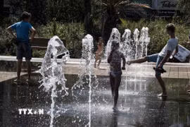 Người dân tránh nóng bên đài phun nước ở Nice, Pháp. (Ảnh: THX/TTXVN)