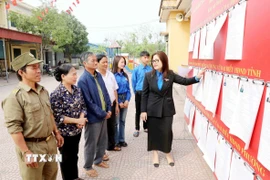 Đoàn Thanh niên phường Hồng Châu (Hưng Yên) thông tin về người ứng cử cho cử tri tại khu vực bỏ phiếu. (Ảnh: Thu Hoài/TTXVN)