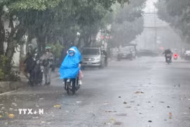Người dân mặc đồ bảo hộ chống nắng khi di chuyển trên đường. (Ảnh: Nguyên Lý/TTXVN)