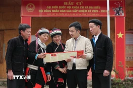 Cán bộ tuyên truyền bầu cử cho các cử tri tại thôn Nặm Đăm, xã Quản Bạ. (Ảnh: Minh Đức/TTXVN)