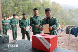 Các chiến sỹ Tiểu đoàn 1, Lữ đoàn 543, Quân khu 2 tiến hành bỏ phiếu vào thùng phiếu phụ của Tổ bầu cử số 1, xã Sín Thầu. (Ảnh: Trung Kiên/TTXVN)