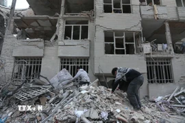 Người dân tìm kiếm đồ đạc trong đống đổ nát của những tòa nhà bị phá hủy sau các cuộc tấn công tại Tehran, Iran, ngày 12/3/2026. (Ảnh: THX/TTXVN)