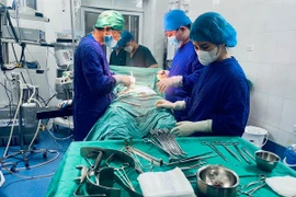 Các bác sĩ thực hiện ca phẫu thuật cho bệnh nhân. (Ảnh: PV/Vietnam+)