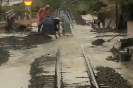 Đoạn đường sắt bị nước ngập, đất đá tràn vào đường ray, gây mất an toàn ở địa phận đường sắt chạy ngang xã Nam Cam Ranh, Khánh Hòa. (Ảnh: TTXVN phát)