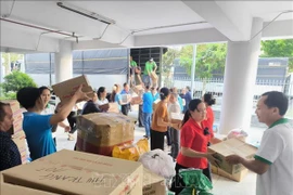 Vận chuyển hàng hóa cứu trợ lên xe chuyển ra miền Trung, Tây Nguyên. (Ảnh: Huỳnh Phúc Hậu/TTXVN)