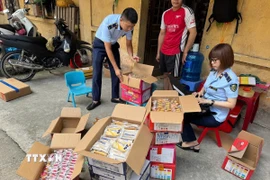 Lực lượng chức năng thu giữ bánh trung thu không rõ nguồn gốc xuất xứ. (Ảnh: TTXVN phát)