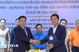 Ông Lê Huy Hoàng, Tổng Giám đốc Công ty Trách nhiệm hữu hạn KN Vientiane Group và ông Bouavieng Champaphan, Giám đốc Công ty Trách nhiệm hữu hạn Bất động sản Real Concept trao đổi văn kiện hợp tác sau lễ ký. (Ảnh: Văn Phiên/TTXVN)