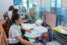 Cán bộ Trung tâm phục vụ hành chính công xã Nam Minh, tỉnh Ninh Bình làm thủ tục cho người dân. (Ảnh: Công Luật/TTXVN)