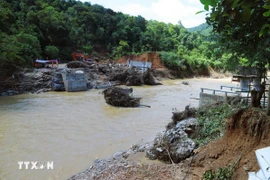 Nước lũ cuốn trôi nhịp cầu Xốp Chạng trên Quốc lộ 48C, làm biến dạng hoàn toàn lòng suối khu vực hai bên cầu. (Ảnh: Xuân Tiến/TTXVN)