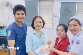 Bé sơ sinh được xuất viện trong niềm vui của gia đình và đội ngũ y bác sỹ. (Ảnh: TTXVN phát)
