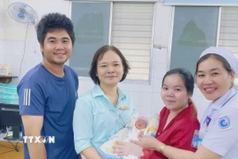 Bé sơ sinh được xuất viện trong niềm vui của gia đình và đội ngũ y bác sỹ. (Ảnh: TTXVN phát)