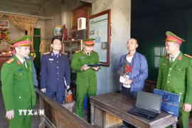 Cơ quan Cảnh sát điều tra Công an tỉnh thi hành lệnh bắt bị can Lê Minh Vũ. (Ảnh: TTXVN phát)