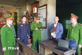 Cơ quan Cảnh sát điều tra Công an tỉnh thi hành lệnh bắt bị can Lê Minh Vũ. (Ảnh: TTXVN phát)