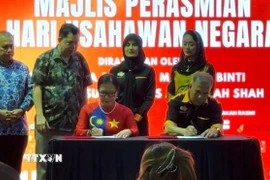 Chủ tịch Hiệp hội hữu nghị Malaysia – Việt Nam Trần Thị Chang (trái) và Chủ tịch Phòng Thương mại doanh nhân Malaysia Abu Hasan (phải) ký thỏa thuận hợp tác. (Ảnh: Viên Luyến/TTXVN)