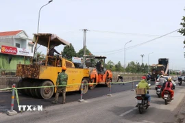 Thi công hoàn trả mặt bằng Quốc lộ 1 đoạn qua Khu công nghiệp VSIP. (Ảnh: Phạm Cường/TTXVN)
