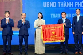 Phó chủ tịch Ủy ban Nhân dân Thành phố Hồ Chí Minh Trần Thị Diệu Thúy tặng cờ truyền thống cho Báo Thanh Niên. (Ảnh: Độc Lập)