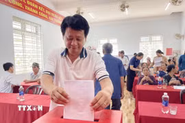 Người dân thôn Tuyết Diêm 3, xã Vạn Tường (Quảng Ngãi) nêu ý kiến bằng phiếu về Đề án tổ chức lại thôn trên địa bàn. (Ảnh: Phạm Cường/TTXVN)